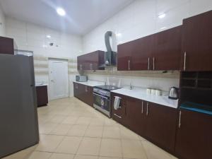 Una cocina grande con gabinetes y electrodomésticos marrones. en Luxury Lagos House with 4 Bedrooms, en Lagos