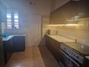 una cocina con fregadero y estufa horno superior en Luxury Lagos House with 4 Bedrooms, en Lagos