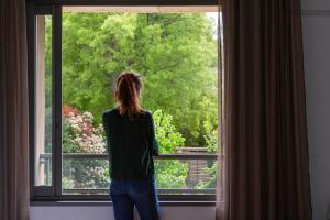 a woman is looking out of a window at Hôtel 96 in Marseille