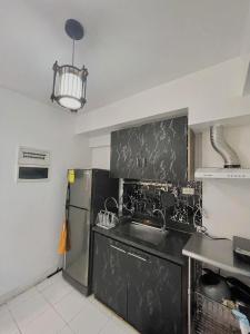 Una cocina con fregadero y frigorífico de acero inoxidable. en Condo in Davao city 2 bedroom Camella north point, en Davao City