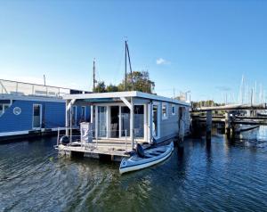 吕贝克Hausboot Janne Lübeck Inclusive Kanu nach Verfügbarkeit SUP und WLAN 50 MBit s Flat的一艘蓝色的小船停靠在码头