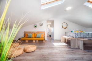 an attic living room with a couch and a tub at Istrian Embrace, KIŽIN House - Cozy apartments in Brezovica pri Gradinu