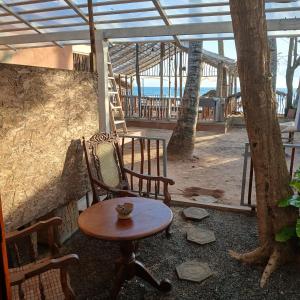 a table and chair in a room with a view of the ocean at La-Vira Beach Villa in Hikkaduwa +47 photos