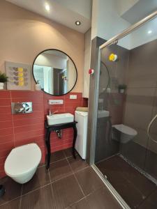 a bathroom with a toilet and a sink and a shower at Kasprzaka Apartment parking in Łódź
