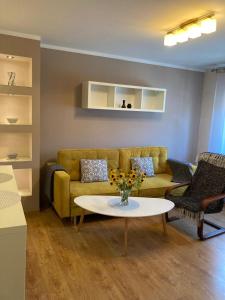 a living room with a yellow couch and a table at Chillout in Stargard