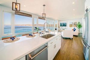 a kitchen with white countertops and a view of the ocean at Spectacular La Jolla Cove Compound in San Diego +62 photos