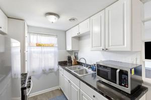 a white kitchen with a sink and a microwave at Heights Dream Libby Unit 6 in Maple Heights