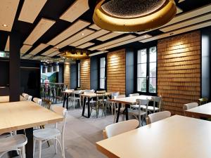 a restaurant with tables and chairs and a large ceiling at Café Tivoli in Châtel-Saint-Denis