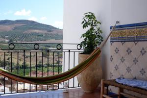 a hammock on a balcony with a view at Casa Frasquita del Pan - Caminito del Rey in Valle de Abdalagís