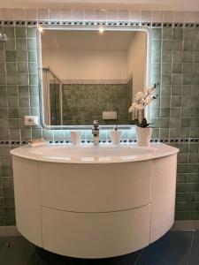 een badkamer met een grote spiegel en een wastafel bij Domus Dolce Vita - Apartment in Rome