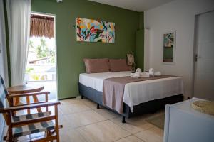 een slaapkamer met een bed in een kamer met groene muren bij Pousada Coconut Cumbuco in Cumbuco +134 foto's