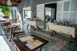 een woonkamer met 2 tafels en stoelen bij Pousada Coconut Cumbuco in Cumbuco