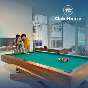 a man and a boy playing a game of pool at Vacacional Bluú Hábitat Lagoons in Los Cerritos