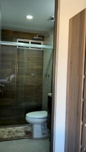 a bathroom with a toilet and a glass door at Vacacional Bluú Hábitat Lagoons in Los Cerritos