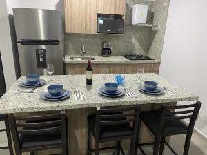a kitchen with a table with chairs and a bottle of wine at Vacacional Bluú Hábitat Lagoons in Los Cerritos