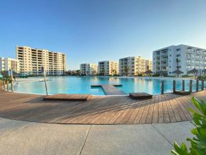 a large swimming pool in a city with tall buildings at Vacacional Bluú Hábitat Lagoons in Los Cerritos