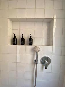 a bathroom with a shower with bottles on the wall at Hidalga Piso con terraza y vistas al mar in Puertito de Güímar