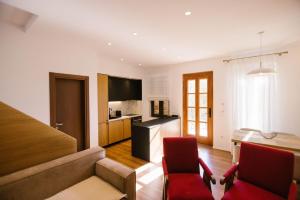 a living room with a couch and chairs and a kitchen at Vila 66 in Korçë