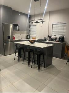 a kitchen with a table with chairs and a refrigerator at Modern 3 bedroom Urban Getaway in Cape Town
