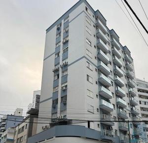 a tall building with balconies on the side of it at Apto espaçoso uma quadra do mar com garagem in Balneário Camboriú