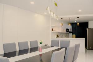 マニラにあるChez les Duques, BF Homes, Paranaqueのテーブルと椅子のあるダイニングルーム