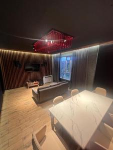 a living room with a table and a couch at Atyrau Avenue in Vorobʼyëvka +32 photos