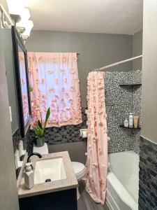 亚克朗Akron Abode - 2pm Check In & Out的浴室设有粉红色的淋浴帘和水槽