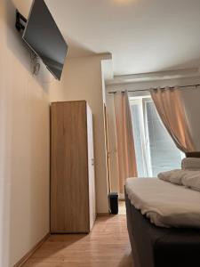 a bedroom with a bed and a tv on the wall at Shirdel Pension in Gaimersheim