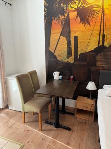a table and chairs in a room with a painting at Shirdel Pension in Gaimersheim