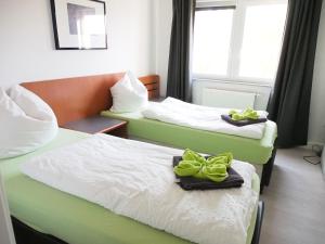 two beds in a hotel room with towels on them at Gemeinschaftsapartment 8 - Ferienwohnung Ottendorf-Okrilla in Ottendorf-Okrilla