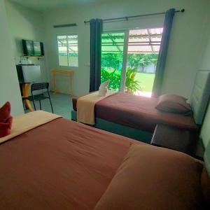 a hotel room with two beds and a window at Davy Cottage Phuket in Ban Riang +57 photos