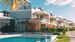 a house with a swimming pool in front of it at Vista Cana Rooftop Picuzzy Apartment in Punta Cana