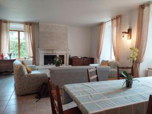 a living room with a table and chairs and a fireplace at Le château d'Aude in Gironcourt-sur-Vraine