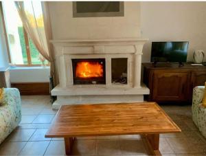 a living room with a fireplace and a coffee table at Le château d'Aude in Gironcourt-sur-Vraine