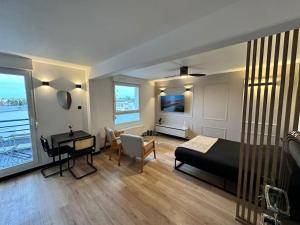 a bedroom with a bed and a desk and a room with a desk at Charmant Studio Neuf, Hypercentre, Parking, Balcon in Strasbourg
