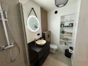 a bathroom with a sink and a mirror at Charmant Studio Neuf, Hypercentre, Parking, Balcon in Strasbourg