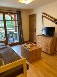 a living room with a bed and a wooden dresser at Appartement T2+coin nuit 6 pers résidence de Cami Real au centre du village de saint Lary Soulan avec piscine intérieure+ sauna et hammam in Saint-Lary-Soulan
