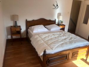 a bed in a bedroom with two night stands and two lamps at Grande maison à à Bresse avec jacuzzi cheminée et jardin Idéal pour les familles et amis in La Bresse