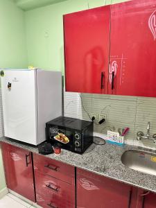 a kitchen counter with a microwave and a sink at Broadway Living in Rāmkot