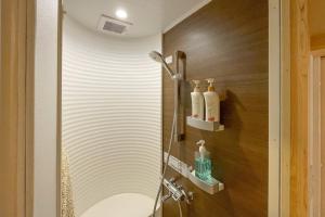 a bathroom with a shower with a sink at Koyasan Shukubo Saizenin in Koyasan