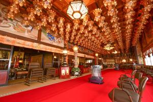 a large room with chairs and a red carpet and chandeliers at Koyasan Shukubo Saizenin in Koyasan