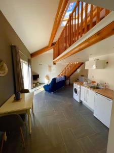 a living room with a kitchen and a staircase at Appartement Cosy avec extérieur au calme in Rocbaron