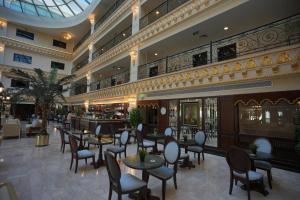 a restaurant with tables and chairs in a building at Habitat Hotel All Suites - Jeddah in Jeddah