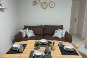 een woonkamer met een tafel en een bruine bank bij Apartamento La Barrosa Beach in Novo Sancti Petri