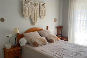 een slaapkamer met een bed met witte lakens en kussens bij Apartamento La Barrosa Beach in Novo Sancti Petri