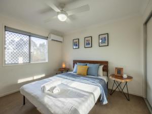 a bedroom with a large bed and a window at Cozy 3B2B Townhouse w Parking Backyard Malls and Parks in Rochedale South