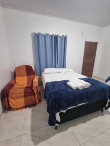 a bedroom with two beds and a blue curtain at Pousada Talismã in Barreirinhas +79 photos