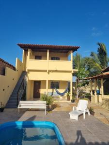 a villa with a swimming pool and a house at Pousada Talismã in Barreirinhas