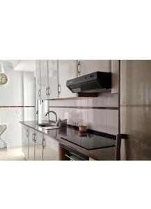 eine Küche mit Spüle und Herd in der Unterkunft El Roque de Garachico in Garachico + 17 Fotos