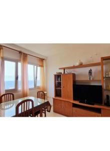 ein Wohnzimmer mit Tisch und Fernseher in der Unterkunft El Roque de Garachico in Garachico